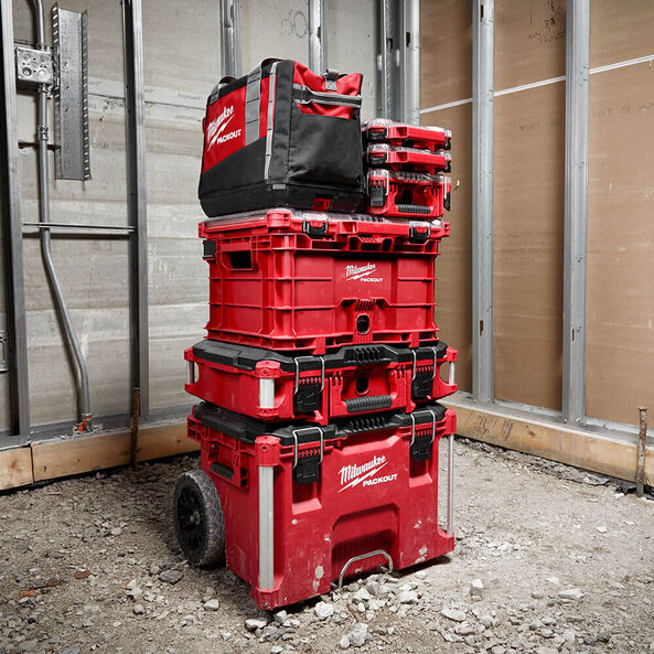 This is an image of stacked red Milwaukee Packout toolboxes and bag at a construction site, offered by Kennedys Welding Supplies in Derwent Park TAS