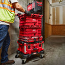 This is an image of a person handling red Milwaukee Packout toolboxes stacked on a wheeled base in an industrial setting at Kennedys Welding Supplies in Derwent Park, Tasmania, offering tool shop and welding specialist services.