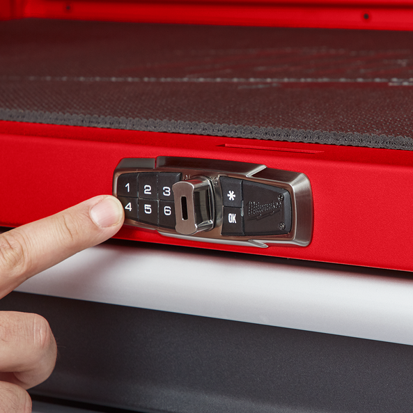 This is an image of a finger pressing a keypad lock on a red Milwaukee tool chest, featured by Kennedys Welding Supplies in Derwent Park TAS