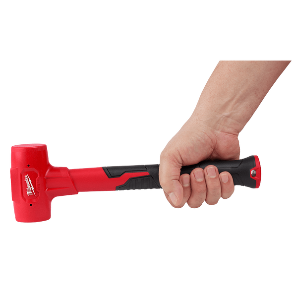 This is an image of a hand holding a red and black Milwaukee rubber mallet, showcasing welding and tool supplies from Kennedys Welding Supplies in Derwent Park, TAS, offering tool shop and power tool repairs.