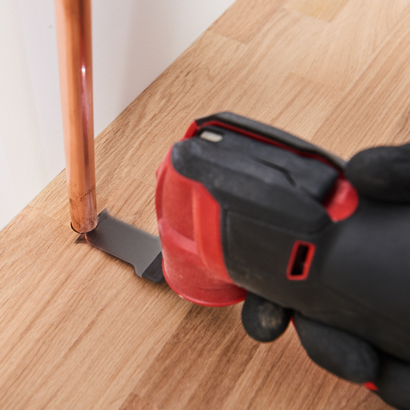 This is an image of a power tool cutting wood near a copper pipe, showcasing precision from Kennedys Welding Supplies, Derwent Park TAS, experts in tool shop and power tool repairs.