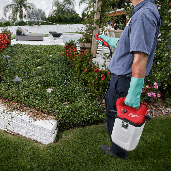 This is an image of a person using a Milwaukee sprayer outdoors, showcasing power tools offered by Kennedys Welding Supplies in Derwent Park, TAS