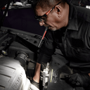 This is an image of a technician using a pen light inspecting a car engine at Kennedys Welding Supplies in Derwent Park TAS, offering tool shop and power tool repairs