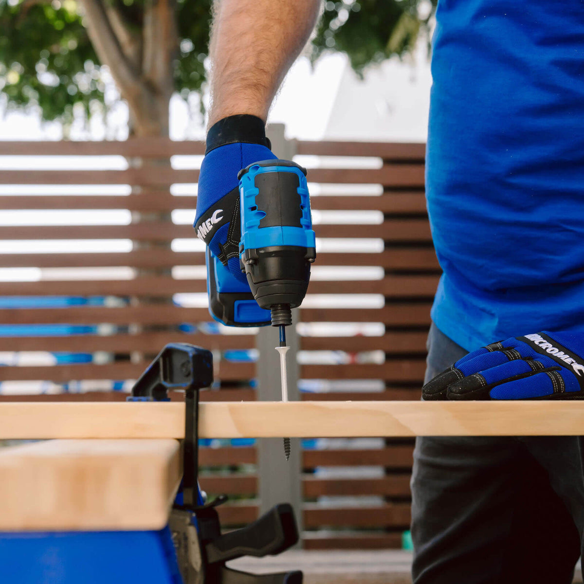 This is an image of a person using a blue power drill to screw into wood, highlighting welding and power tool repairs by Kennedys Welding Supplies in Derwent Park TAS
