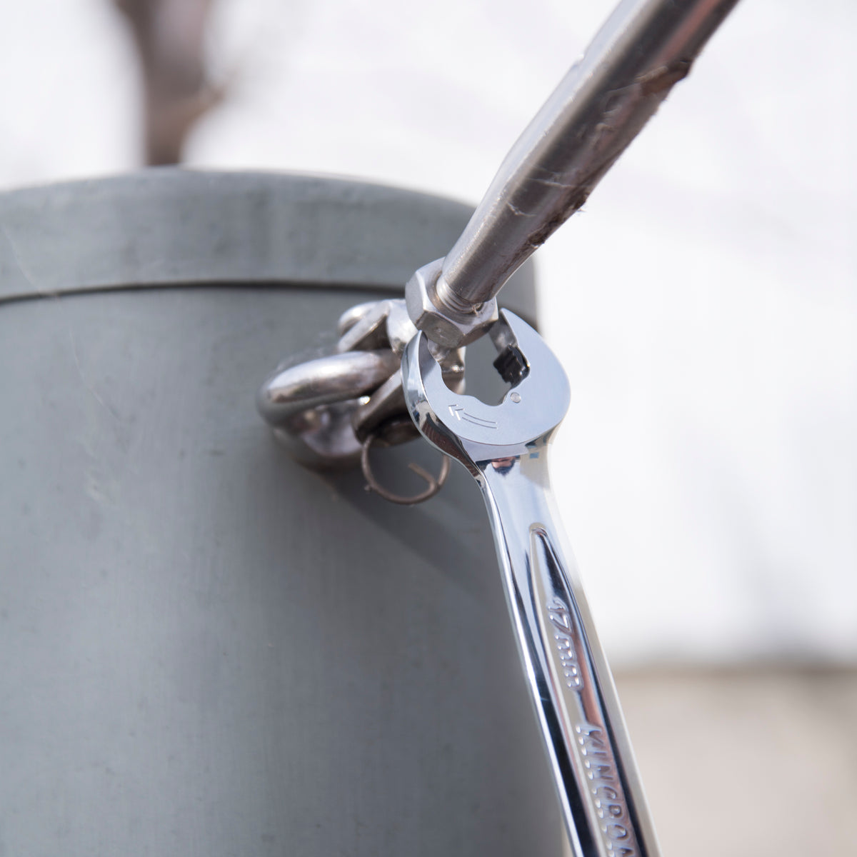 This is an image of a chrome Kincrome wrench tightening a bolt on a metal pipe, featured by Kennedys Welding Supplies in Derwent Park TAS, offering tool shop and welding specialist services.
