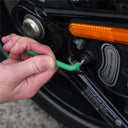 This is an image of hand using a green hex key wrench on a black Harley-Davidson motorcycle part with an orange reflector, showcasing precision tool use at Kennedys Welding Supplies, Derwent Park TAS, experts in Tool Shop, Power Tool Repairs, and Welding Specialists.