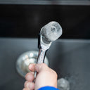 This is an image of a hand holding a chrome wrench with a clear ice cube formed on the tool at Kennedys Welding Supplies in Derwent Park TAS