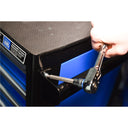 This is an image of a hand using a wrench to fix a blue tool cabinet with Automatic Drawer Retention System at Kennedys Welding Supplies Tool Shop in Derwent Park, TAS