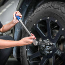 This is an image of a person using a torque wrench on a black off-road vehicle tire, showcasing Kennedys Welding Supplies in Derwent Park TAS, offering tool shop and power tool repairs