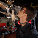 This is an image of a mechanic inspecting car parts in a workshop, representing Kennedys Welding Supplies in Derwent Park TAS, offering tool shop, welding specialists, and power tool repairs