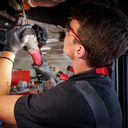This is an image of a technician using a Milwaukee power tool for vehicle repair in a workshop, representing Kennedys Welding Supplies in Derwent Park, TAS, offering tool shop and power tool repairs