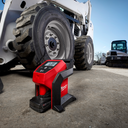 This is an image of a Milwaukee M12 BI-0 laser measuring device on the ground near heavy machinery tires at Kennedys Welding Supplies Derwent Park TAS