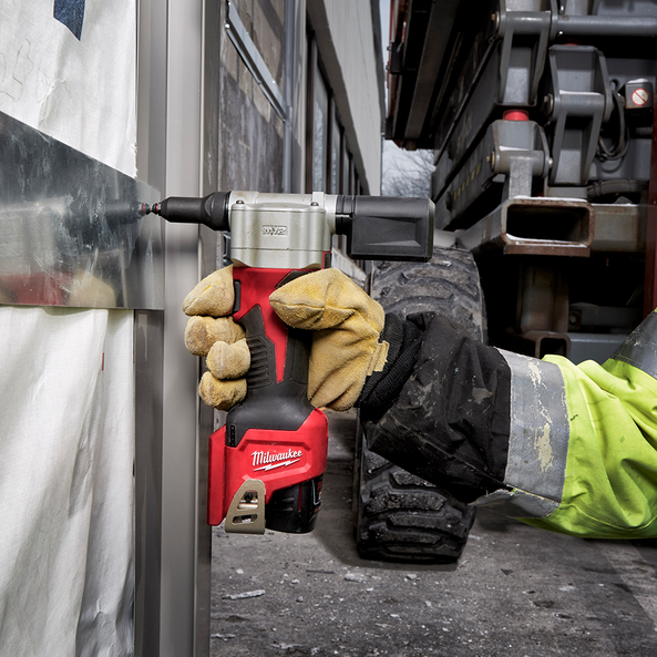 This is an image of a gloved hand using a red Milwaukee power tool on metal at Kennedys Welding Supplies, Derwent Park TAS