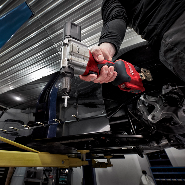 This is an image of a hand holding a red Milwaukee power tool in a workshop, promoting Kennedys Welding Supplies in Derwent Park TAS, offering tool shop and power tool repairs