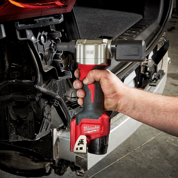 This is an image of a hand using a Milwaukee M12 cordless impact wrench on a vehicle, showcasing power tool repair at Kennedys Welding Supplies in Derwant Park TAS
