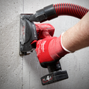 This is an image of a person using a Milwaukee M12 cordless power tool on a concrete wall, representing Kennedys Welding Supplies in Derwent Park TAS with tool shop and power tool repairs