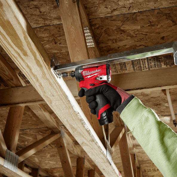 This is an image of a worker using a red Milwaukee power tool on a wooden beam, showcasing tool use at Kennedys Welding Supplies in Derwent Park, Tasmania