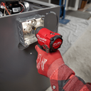 This is an image of a person using a red Milwaukee brushless power tool on metal, showcasing Kennedys Welding Supplies in Derwent Park TAS tool shop