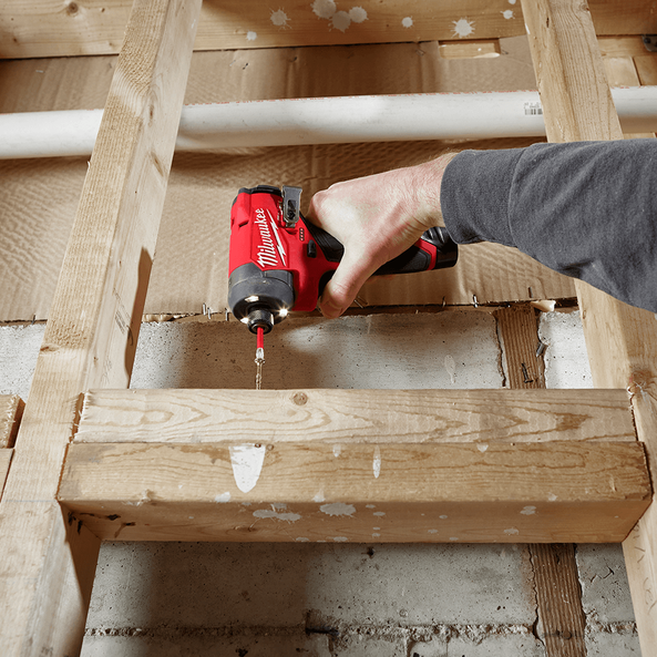 This is an image of a hand using a red Milwaukee power drill on wooden beams in a workshop, from Kennedys Welding Supplies in Derwent Park TAS offering tool shop and power tool repairs