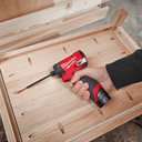 This is an image of a hand holding a red Milwaukee cordless screwdriver working on wood, showcasing tools from Kennedys Welding Supplies in Derwent Park, TAS, offering tool shop, power tool repairs, and welding specialists.