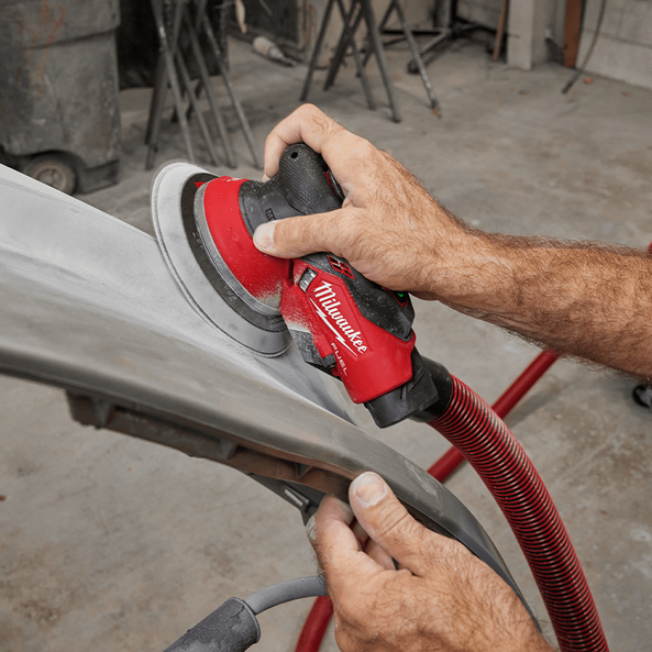 This is an image of a person using a Milwaukee power tool to sand a metal surface, representing Kennedys Welding Supplies in Derwent Park, TAS, offering tool shop services, welding specialists, and power tool repairs.