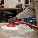 This is an image of a person using a red Milwaukee power sander on a metal surface at Kennedys Welding Supplies in Derwent Park, TAS, offering tool shop and welding specialist services
