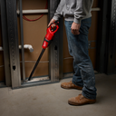 This is an image of a person using a red Milwaukee power tool in a construction setting, offered by Kennedys Welding Supplies in Derwent Park, TAS, specializing in tool shop, power tool repairs, and welding services.