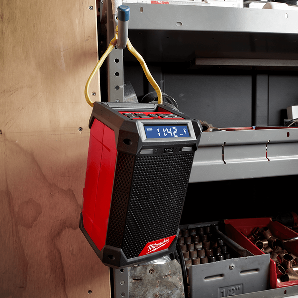 This is an image of a Milwaukee jobsite radio hanging on a metal shelf in a workshop, featured by Kennedys Welding Supplies in Derwent Park TAS offering tool shop and welding specialist services