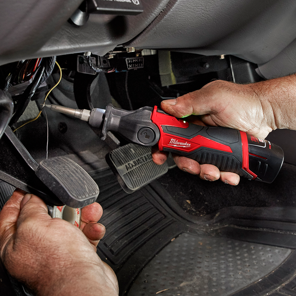 This is an image of hands using a Milwaukee power tool under a vehicle dashboard, showcasing Kennedys Welding Supplies services in Derwent Park TAS