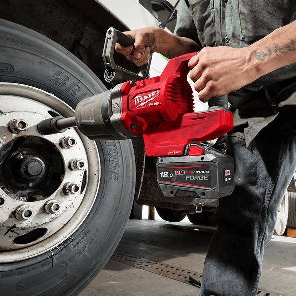 This is an image of a person using a Milwaukee M18 Fuel power tool on a large vehicle tire, featured by Kennedys Welding Supplies in Derwent Park TAS offering Tool Shop and Power Tool Repairs