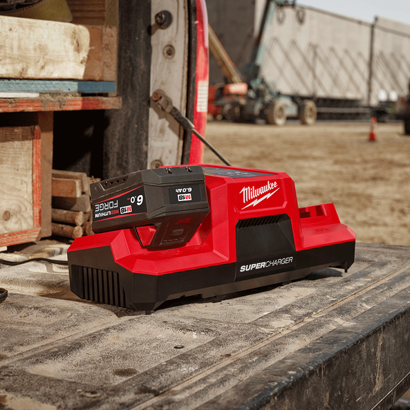 This is an image of a red Milwaukee Super Charger battery charger on a truck bed, ideal for tool charging at Kennedys Welding Supplies in Derwent Park TAS, offering tool shop and power tool repairs