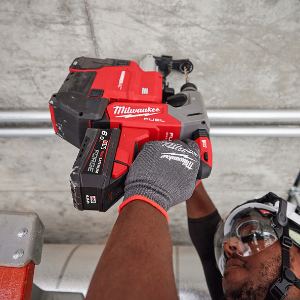 This is an image of a person using a red Milwaukee M18 Fuel power tool for metal work, showcasing Kennedys Welding Supplies in Derwent Park, TAS, offering welding specialists and tool shop services.