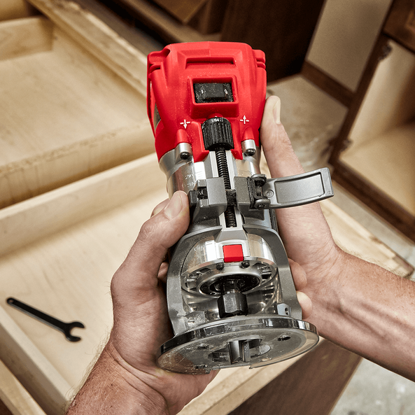 This is an image of a red handheld woodworking router tool held over a wooden box frame, highlighting precision cutting, featured by Kennedys Welding Supplies in Derwent Park Tasmania, offering tool shop, power tool repairs, laser cutting, and welding specialists.