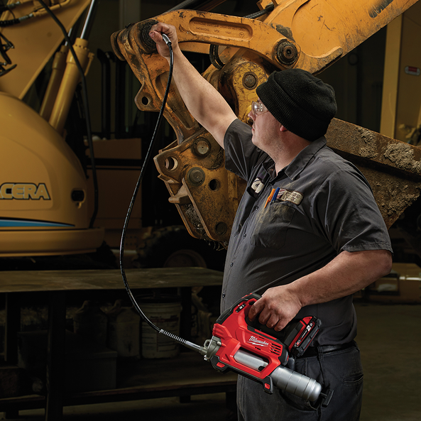 This is an image of a worker using a Milwaukee tool inspecting heavy machinery at Kennedys Welding Supplies in Derwent Park TAS, offering tool shop and power tool repairs.