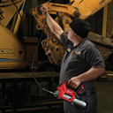 This is an image of a worker using a Milwaukee tool inspecting heavy machinery at Kennedys Welding Supplies in Derwent Park TAS, offering tool shop and power tool repairs.